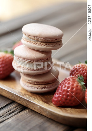 木のお皿にのせたストロベリーマカロンとヘタ付のイチゴ 123746807