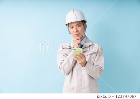ビジネスマン　作業服　スマホ　考える 123747067