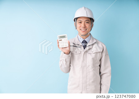 電卓を持つ笑顔の男性　ビジネス　作業服 123747080