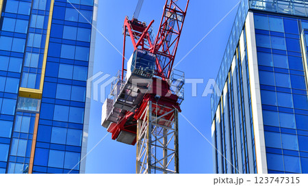 Crane on the construction site in a site surrounded by the high buildings. Crane on the construction site in a site surrounded by the high buildings. 123747315