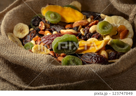 Dried tropical fruits and nuts in burlap bag. 123747849