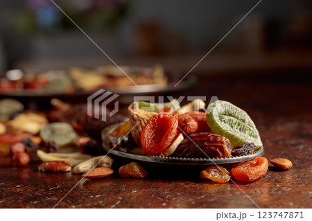 Dried tropical fruits, nuts, and raisins on a kitchen table. Dried tropical fruits, nuts, and raisins on a kitchen table. 123747871