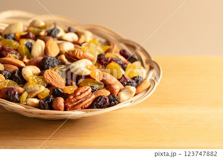 Mix of dried nuts and raisins on a wooden background. 123747882