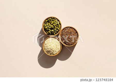 Organic Superfood Trio. Pumpkin Seeds, Flax, Sesame in Rustic Wooden Bowls. 123748184