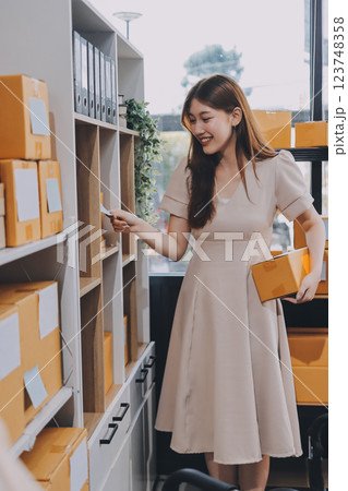 Asian SME business women use laptop computer checking customer order online shipping boxes at home. Starting Small business entrepreneur SME freelance. Online business, Work at home concept. 123748358
