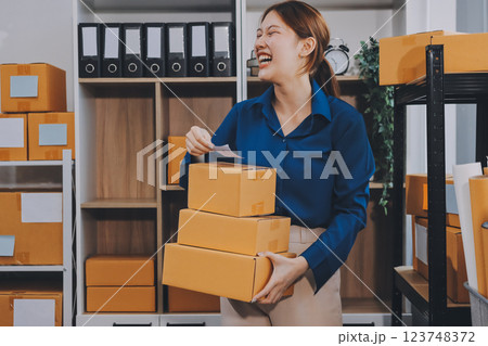 Asian SME business women use laptop computer checking customer order online shipping boxes at home. Starting Small business entrepreneur SME freelance. Online business, Work at home concept. Asian SME business women use laptop computer checking customer order online shipping boxes at home. Starting Small business entrepreneur SME freelance. Online business, Work at home concept. 123748372