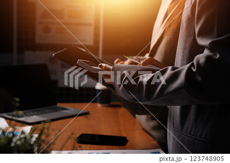 Group of confident business people point to graphs and charts to analyze market data, balance sheet, account, net profit to plan new sales strategies to increase production capacity. Group of confident business people point to graphs and charts to analyze market data, balance sheet, account, net profit to plan new sales strategies to increase production capacity. 123748905