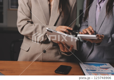 Group of confident business people point to graphs and charts to analyze market data, balance sheet, account, net profit to plan new sales strategies to increase production capacity. 123748906