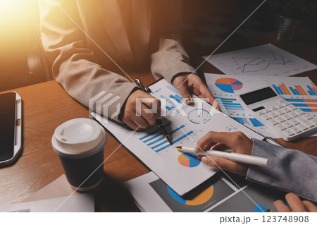 Group of confident business people point to graphs and charts to analyze market data, balance sheet, account, net profit to plan new sales strategies to increase production capacity. Group of confident business people point to graphs and charts to analyze market data, balance sheet, account, net profit to plan new sales strategies to increase production capacity. 123748908