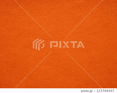 Sunset hues dance on a plush orange felt texture, inviting warmth and vibrant creativity 123749347