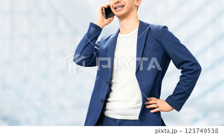スマートフォンで通話をする笑顔の男性ビジネスマン スマートフォンで通話をする笑顔の男性ビジネスマン 123749538