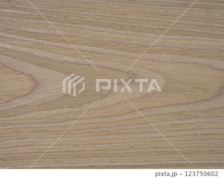 Swirling patterns of ash wood veneer dance in a delicate fusion of tan, wheat, and honeyed tones 123750602