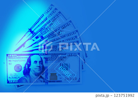 Corruption concept. US Dollar cash money in uv light on blue background Corruption concept. US Dollar cash money in uv light on blue background 123751992