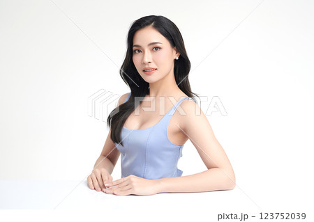 A beautiful young Asian woman with clean, fresh skin against a white background. She represents beauty, skincare, and spa treatments. 123752039