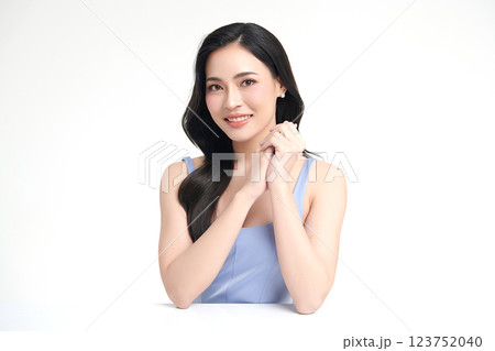 A beautiful young Asian woman with clean, fresh skin against a white background. She represents beauty, skincare, and spa treatments. 123752040