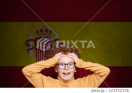 Funny surprised child boy on Spanish flag background. Education and childhood in Spain concept 123752578