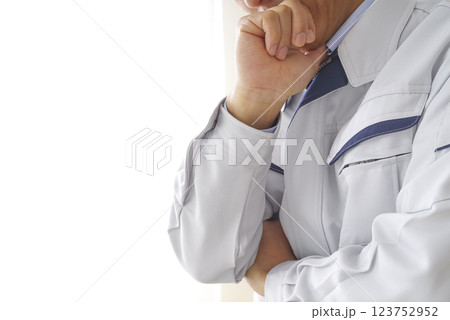 考え事をする作業着の男性 123752952