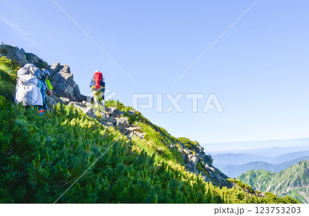 太陽が眩しい、険しい山道を歩く人 太陽が眩しい、険しい山道を歩く人 123753203