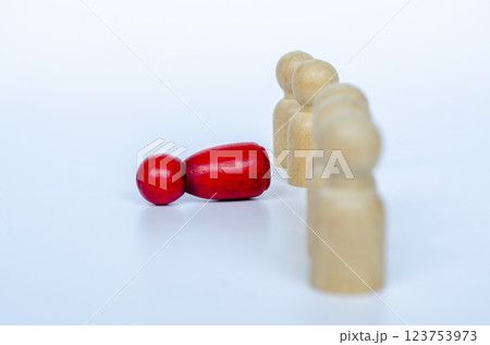 A fallen red wooden doll from the line. Discrimination concept 123753973