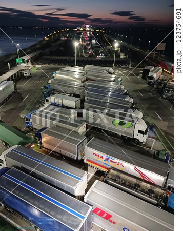 夜のパーキングエリアに集結するトラックの群れ - 高速道路の物流拠点 夜のパーキングエリアに集結するトラックの群れ - 高速道路の物流拠点 123754691