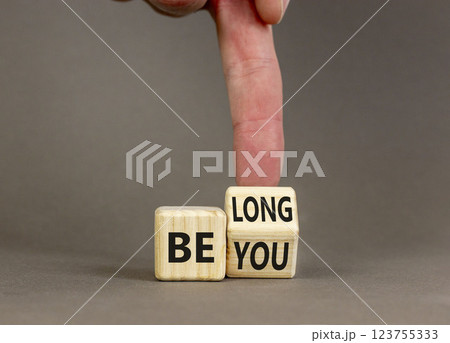 Belonging and belong symbol. Concept words Be you Belong on beautiful wooden block. Beautiful grey background Businessman hand. Business motivational belonging and belong concept. Copy space. 123755333
