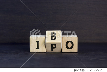 Initial public or bond offering symbol. Concept words abbreviation IPO or IBO on wooden block. Beautiful black table black background. Business Initial public or bond offering concept. Copy space. 123755340