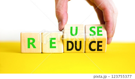 Reuse or reduce symbol. Concept words Reuse Reduce on wooden block. Beautiful yellow table white background. Businessman hand. Business reuse or reduce concept. Copy space. Reuse or reduce symbol. Concept words Reuse Reduce on wooden block. Beautiful yellow table white background. Businessman hand. Business reuse or reduce concept. Copy space. 123755377