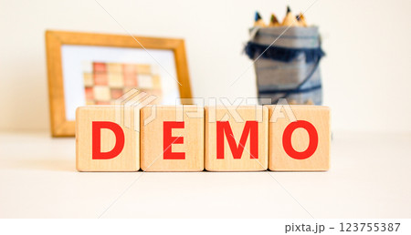 Demo symbol. Concept word Demo on beautiful wooden blocks. Beautiful picture frame and colored pencils. Beautiful white table white background. Business and demo concept. Copy space. 123755387