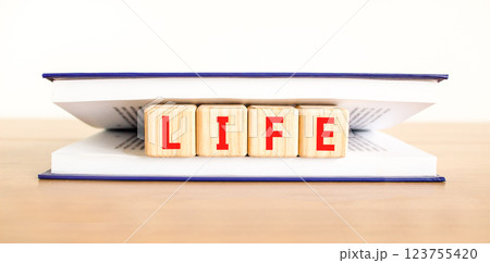 Life symbol. Concept word Life on beautiful wooden blocks in book. Beautiful wooden table white background. Business, lifestyle, support and life concept. Copy space. Life symbol. Concept word Life on beautiful wooden blocks in book. Beautiful wooden table white background. Business, lifestyle, support and life concept. Copy space. 123755420