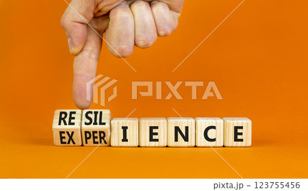 Resilience or experience symbol. Concept words Resilience Experience on beautiful wooden blocks. Beautiful orange background. Businessman hand. Business resilience or experience concept. Copy space 123755456
