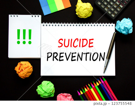 Suicide prevention symbol. Concept words Suicide prevention on beautiful white note. Black calculator. Colored pencils. Beautiful black background. Psychological suicide prevention concept. Copy space 123755548