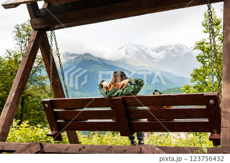 woman relaxing on wooden swing, admiring stunning mountain view. The peaceful outdoor scene captures moment of tranquility and connection with nature, adventure, nature retreat, and outdoor relaxation woman relaxing on wooden swing, admiring stunning mountain view. The peaceful outdoor scene captures moment of tranquility and connection with nature, adventure, nature retreat, and outdoor relaxation 123756432