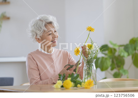 自宅でフラワーアレンジメントをするシニア女性 123756506