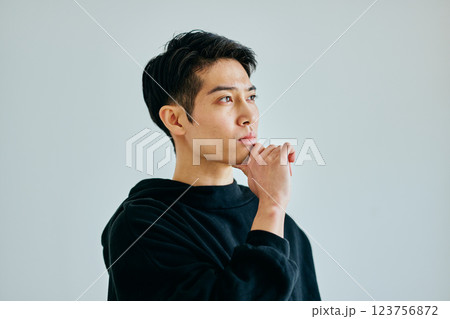 あごに手を当てて考える20代の若い男性 123756872
