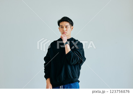 あごに手を当てて考える20代の若い男性 123756876