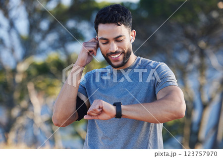 Man, runner and smartwatch outdoor for workout listening to music, radio or streaming on web. Training, running and fitness for guy with tech clock to check heart, blood pressure or steps in summer 123757970