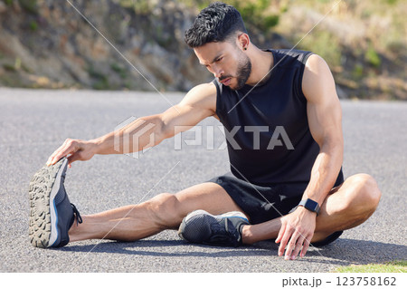 Fitness, exercise and stretching with a sports man preparing for a workout or cardio training on a road in nature. Health, wellness and performance with a male athlete at the start of a routine Fitness, exercise and stretching with a sports man preparing for a workout or cardio training on a road in nature. Health, wellness and performance with a male athlete at the start of a routine 123758162