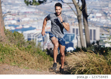 City, runner and man running in nature training, cardio exercise and endurance workout for a marathon. Sports, fitness and healthy athlete on jog on a forest or mountain trail outdoors in summer 123758485