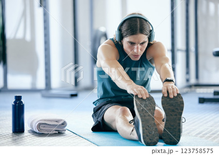 Pilates, yoga and man stretching at gym for training or fitness exercise and streaming audio, music playlist or radio. Wellness, healthy and young athlete listening to podcast before starting cardio 123758575