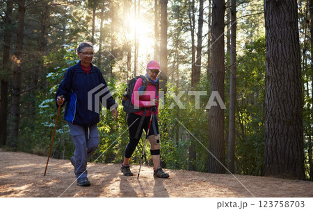 Forest, fitness and old couple hiking in nature with trekking sticks with backpacks on a mountain trail. Retirement, hikers and elderly woman walking with senior partner outdoors in woods in Peru Forest, fitness and old couple hiking in nature with trekking sticks with backpacks on a mountain trail. Retirement, hikers and elderly woman walking with senior partner outdoors in woods in Peru 123758703