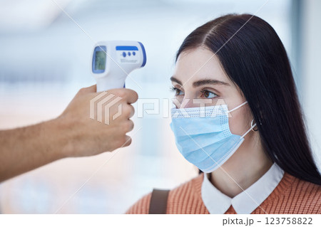 Thermometer, healthcare and covid with a doctor scan a patient temperature with infrared, checking for a fever. Sick woman with mask for corona, flu or cold in exam or consult in a medical clinic Thermometer, healthcare and covid with a doctor scan a patient temperature with infrared, checking for a fever. Sick woman with mask for corona, flu or cold in exam or consult in a medical clinic 123758822