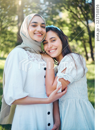 Women happy in garden, forest park with trees and outdoor garden picnic in multicultural summer fashion. Portrait of female friends together, muslim girl in islamic hijab scarf smile and hug friend 123758856