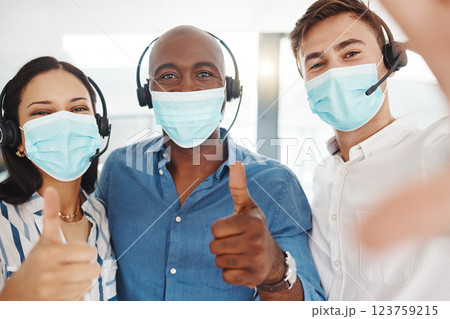 Selfie of covid call center people with thumbs up in face mask for trust, success and thank you company portrait. Diversity telemarketing or customer service agent team for motivation in corona virus Selfie of covid call center people with thumbs up in face mask for trust, success and thank you company portrait. Diversity telemarketing or customer service agent team for motivation in corona virus 123759215