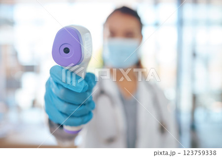 Hand, woman doctor and covid test thermometer laser gun for medical exam, check or covid 19 scan at vaccine center. Healthcare nurse, mask and glove for corona virus safety and protection at clinic 123759338