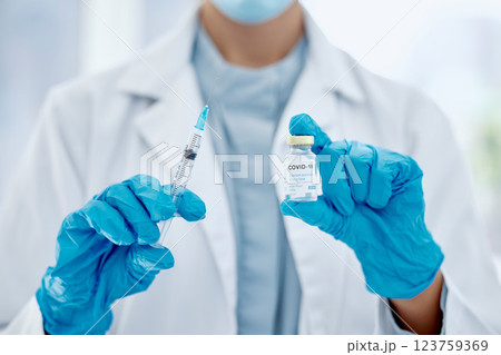 Covid, vaccine and hands of a medical doctor holding the needle and syringe for an injection. Medicine, science and closeup of healthcare worker with a pharmaceutical virus treatment in a glass vial. 123759369