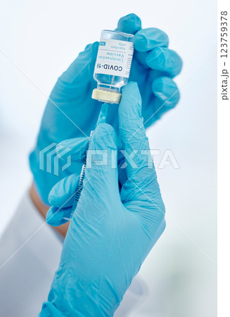 Covid vaccine, healthcare hands and needle for medical safety and protection against corona virus. Doctor with glass bottle liquid container for medicine research innovation, hospital or clinic help Covid vaccine, healthcare hands and needle for medical safety and protection against corona virus. Doctor with glass bottle liquid container for medicine research innovation, hospital or clinic help 123759378