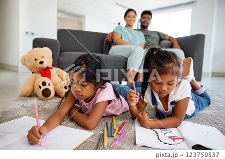 Children drawing, notebook education and parents in living room to relax with kids on floor. Girl siblings writing, studying and doing homework in the lounge with mother and father in family home 123759537
