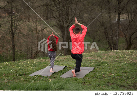 Serenity in motion with children practicing yoga together in a tranquil outdoor setting surrounded by nature during a calm afternoon session Serenity in motion with children practicing yoga together in a tranquil outdoor setting surrounded by nature during a calm afternoon session 123759925