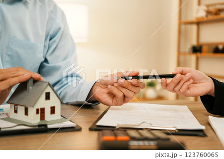 Businesswoman embraces client after successful property negotiation. Businesswoman embraces client after successful property negotiation. 123760065