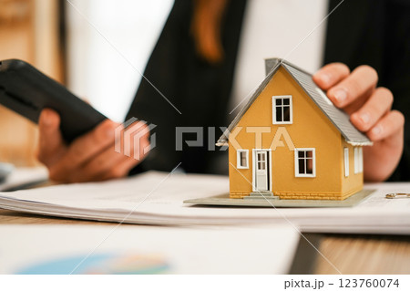 Businesswoman embraces client after successful property negotiation. 123760074